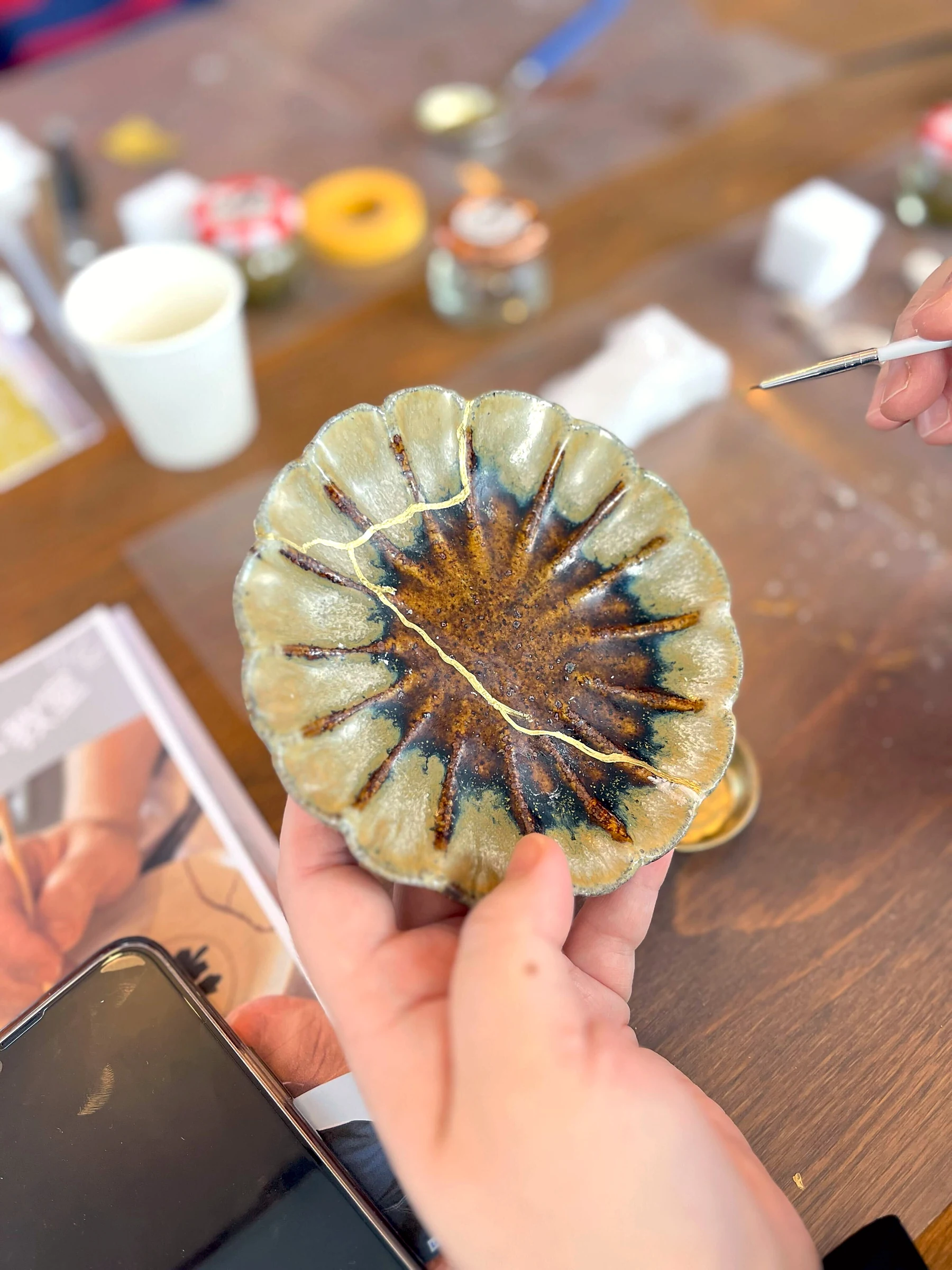修復した菊模様の小鉢を手にしたところ